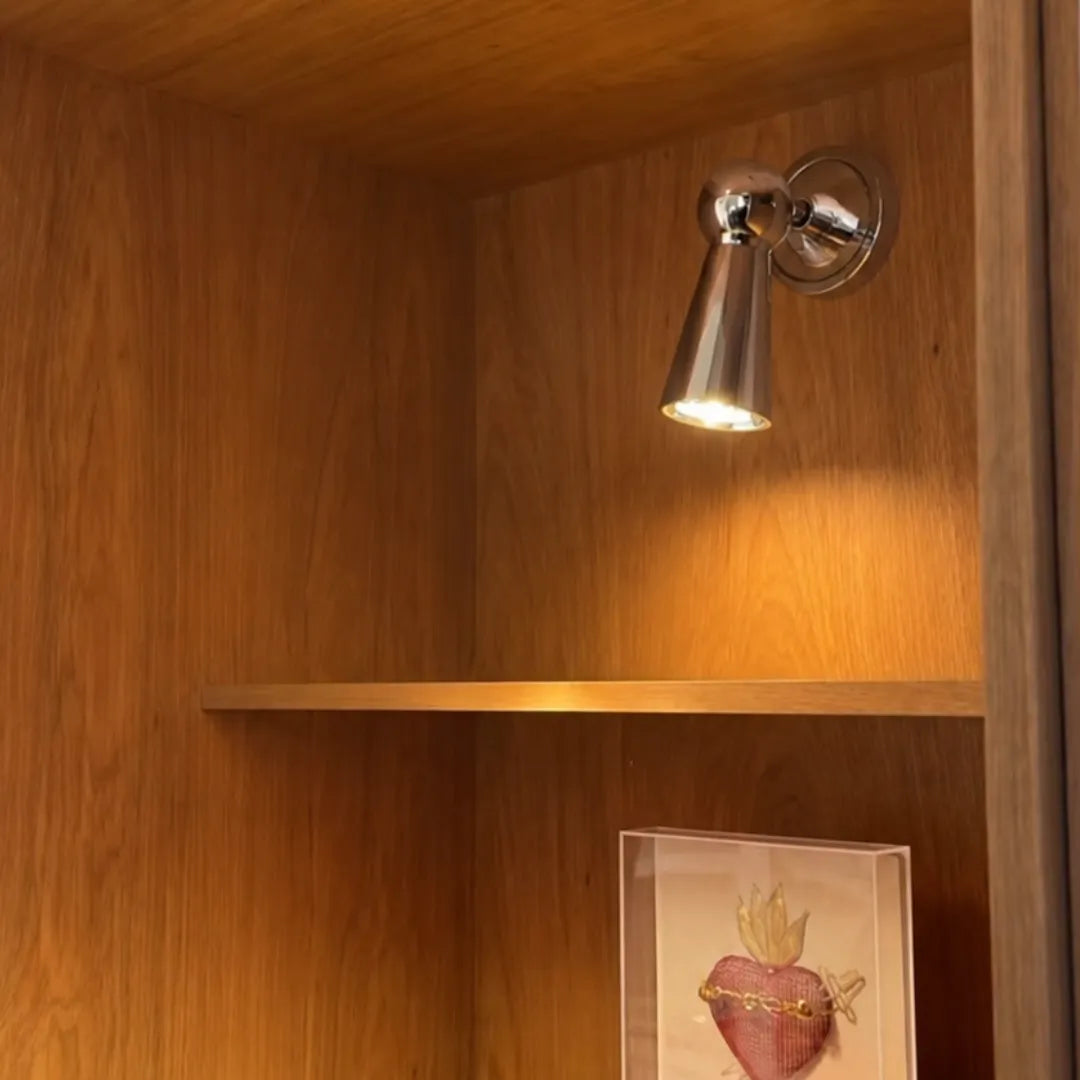 Arandela cromada acesa em sala de leitura com poltrona e estante de livros — Arandela de Parede LED Metal Cromado Ajustável para Leitura — Tonzi