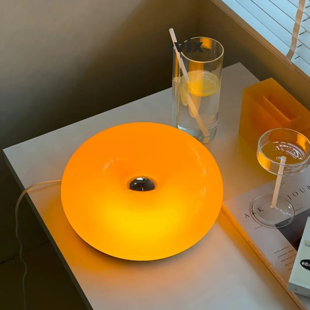 Arandela donut acesa em vista superior sobre mesa com taça e copo em ambiente noturno — Arandela de Parede LED Vidro Donut Laranja Touch Tricolor — Tonzi