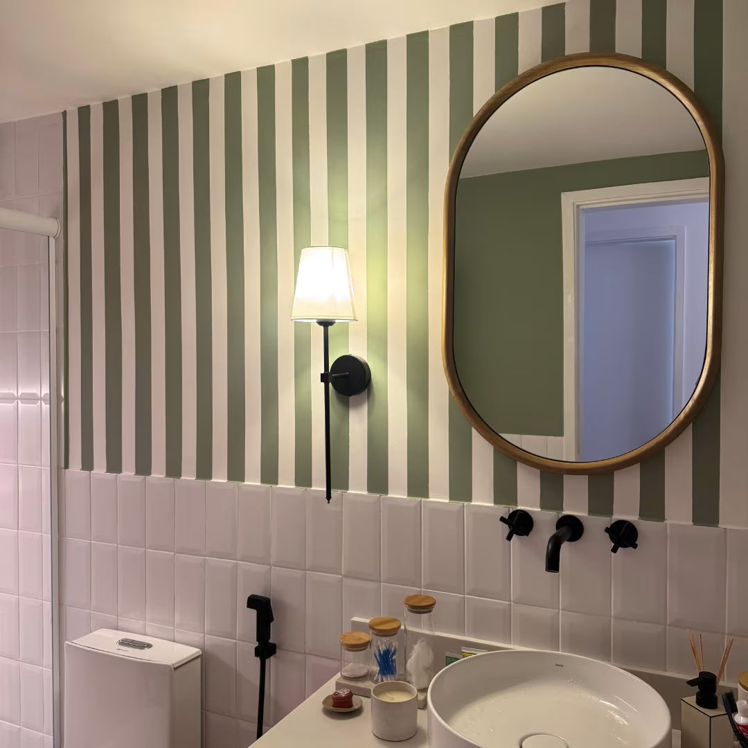 Arandela de parede metal em em preto fosco e abajur tecido no banheiro ao lado do espelho