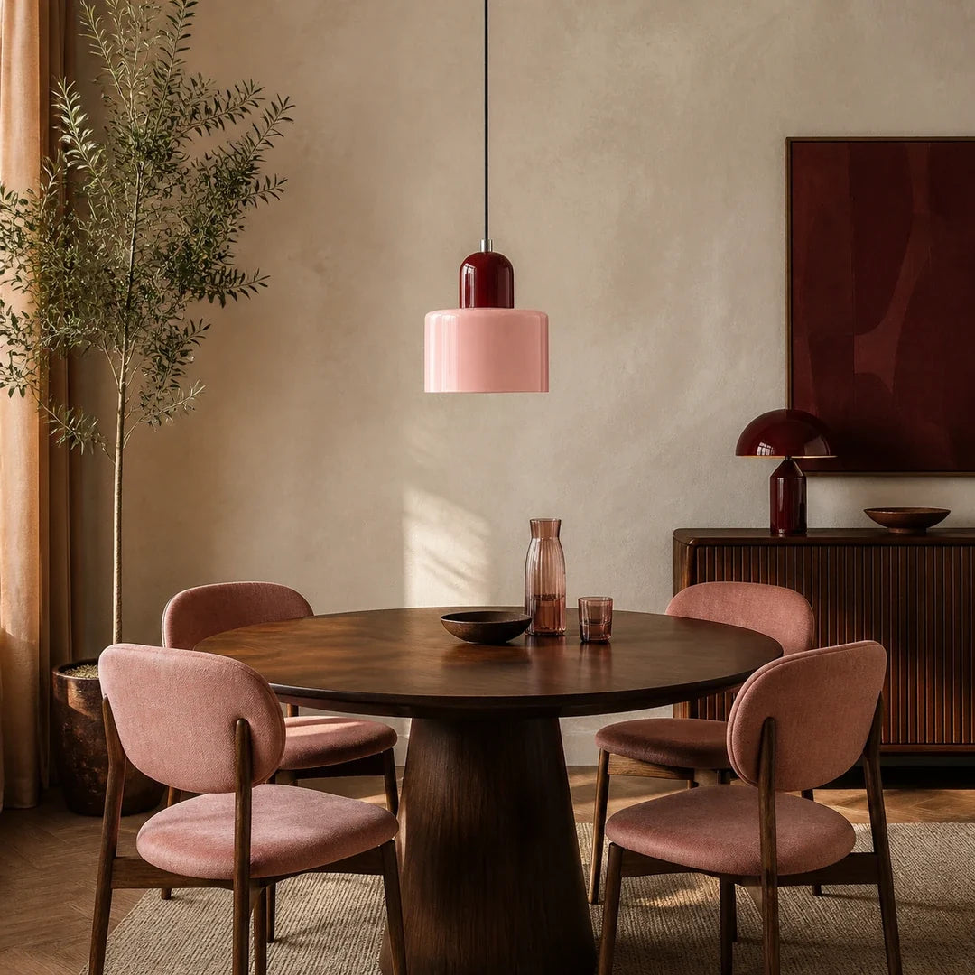 Luminária pendente Croma rosa e vinho instalada sobre mesa redonda em sala de jantar