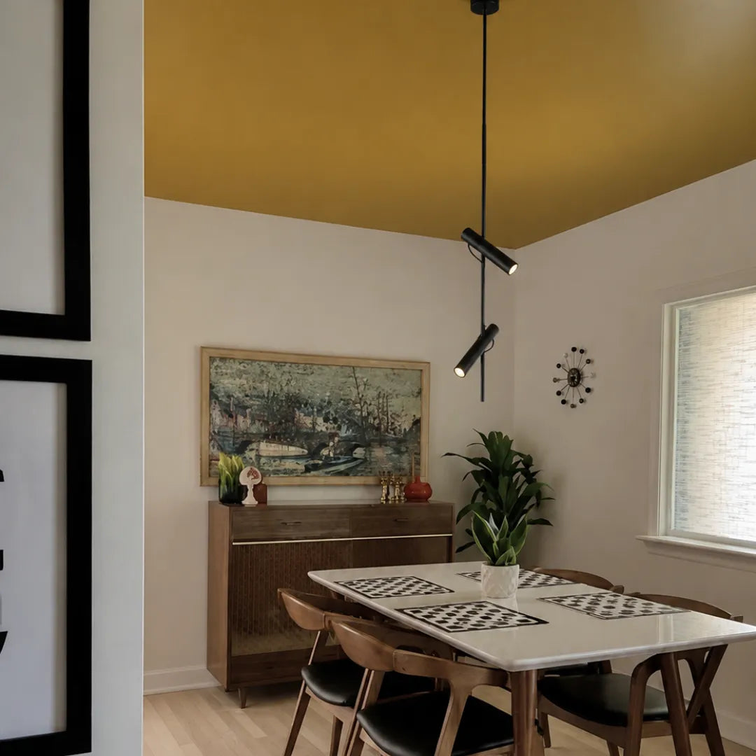Pendente preto com spots rotativos em sala de jantar mid-century com teto mostarda, aparador de madeira e gallery wall — Luminária pendente metal LED rotativa moderna Orbi — Tonzi