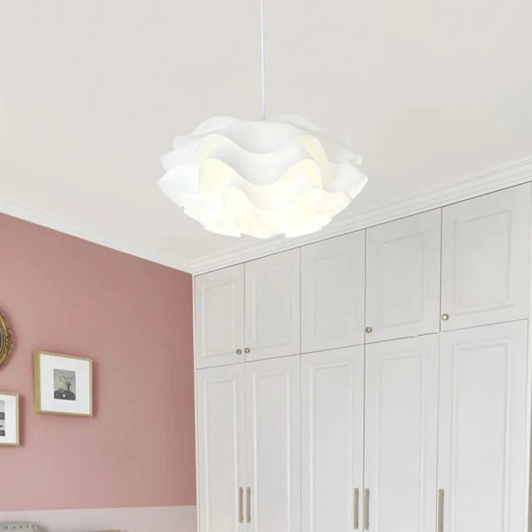 Pendente de pétalas brancas aceso sobre mesa de jantar com parede de quadros e relógio de madeira — Luminária Pendente Tecido LED Minimalista Kaito — Tonzi