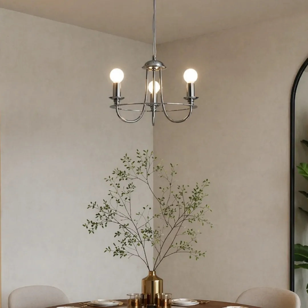 Lustre pendente cromado aceso em sala de jantar minimalista com vaso dourado e galhos de eucalipto — Lustre Pendente Vela Rústico Industrial 3 Luzes Brant — Tonzi