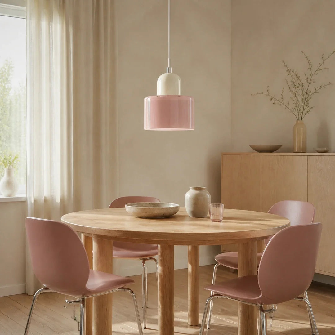 Luminária pendente Croma rosa e creme instalada sobre mesa redonda em sala de jantar escandinava