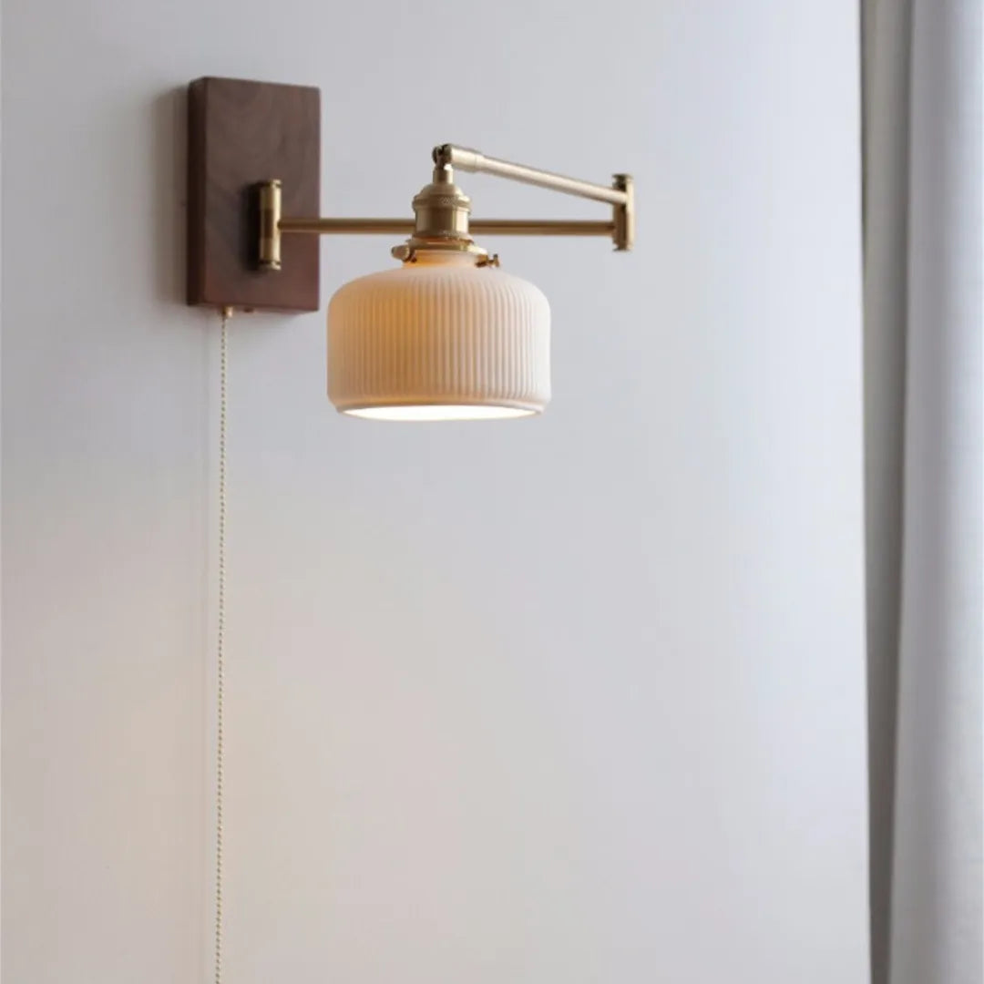 Arandela Eiden montada em parede clara com braço articulado estendido e cordão de acionamento à mostra — Luminária de parede madeira LED braço giratório Eiden — Tonzi