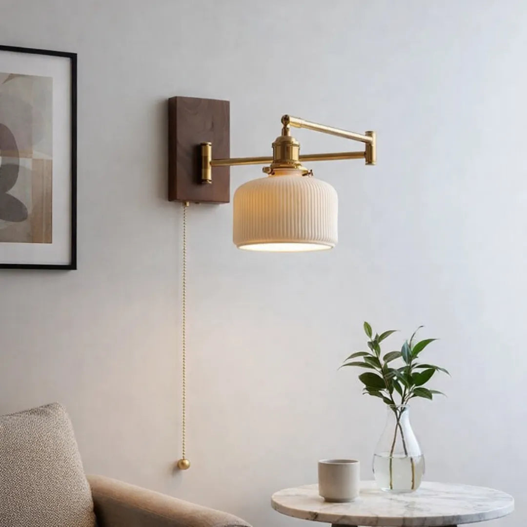 Arandela Eiden em parede clara ao lado de quadro emoldurado e mesa de mármore com vaso de planta em sala de estar minimalista — Luminária de parede madeira LED braço giratório Eiden — Tonzi