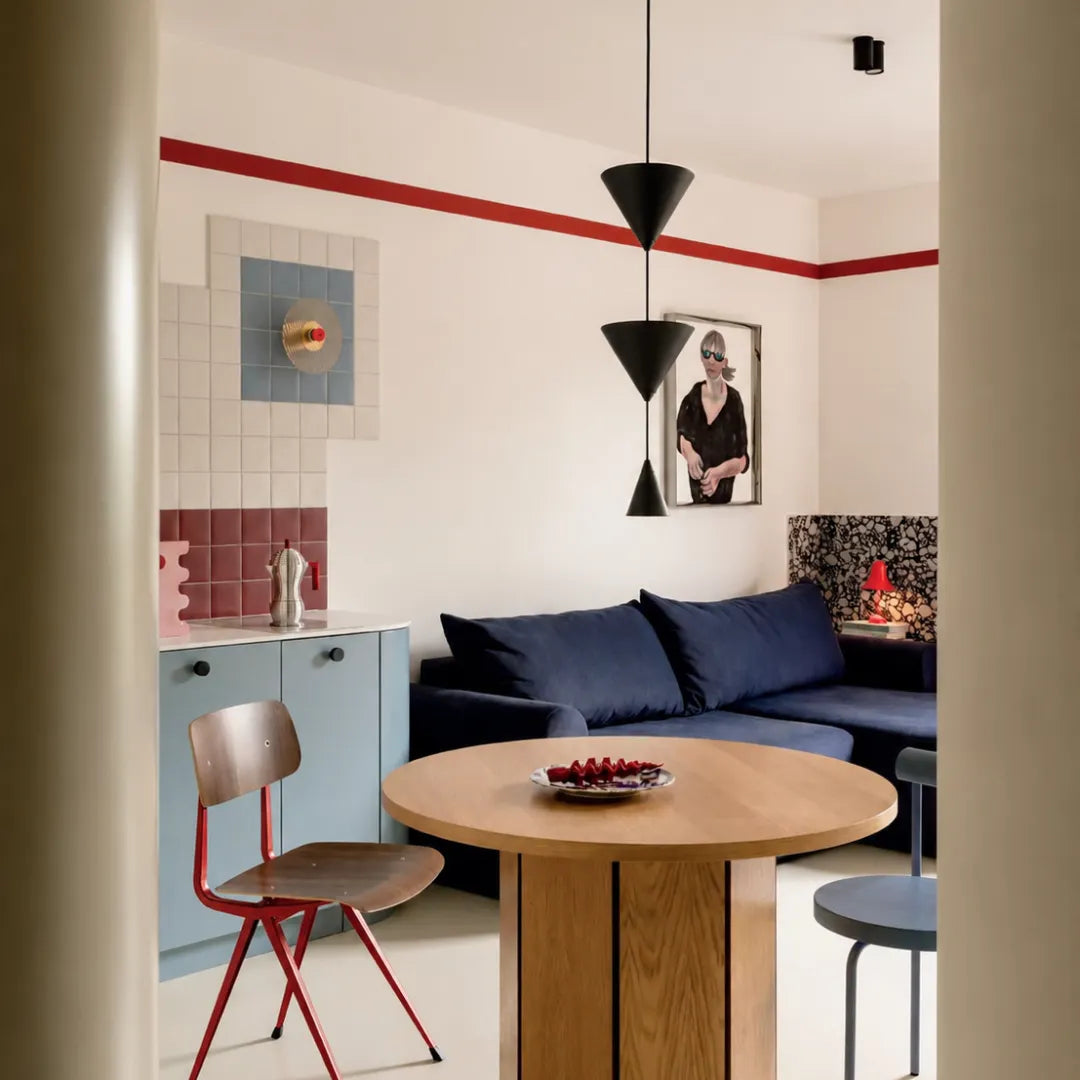 Pendente em metal preto em sala de jantar com pastilhas rosa, mesa de madeira, sofá azul marinho e parede com listra vermelha — Luminária pendente metal LED cônica nórdica Pino — Tonzi