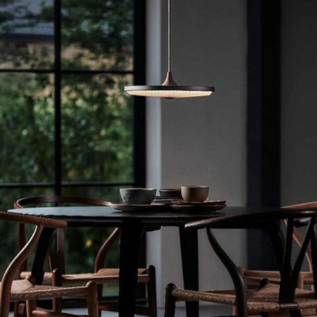 Pendente Eryon disco creme sobre mesa redonda em sala de jantar com vista para jardim — Tonzi
