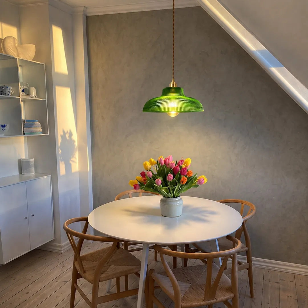 Pendente Halo verde acesa em sala de jantar com mesa redonda branca, cadeiras wishbone de madeira e vaso de tulipas — Luminária Pendente Vidro Cobre Retrô Nórdica Halo — Tonzi